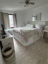 Bedroom featuring wood finished floors, ornamental molding, and ceiling fan