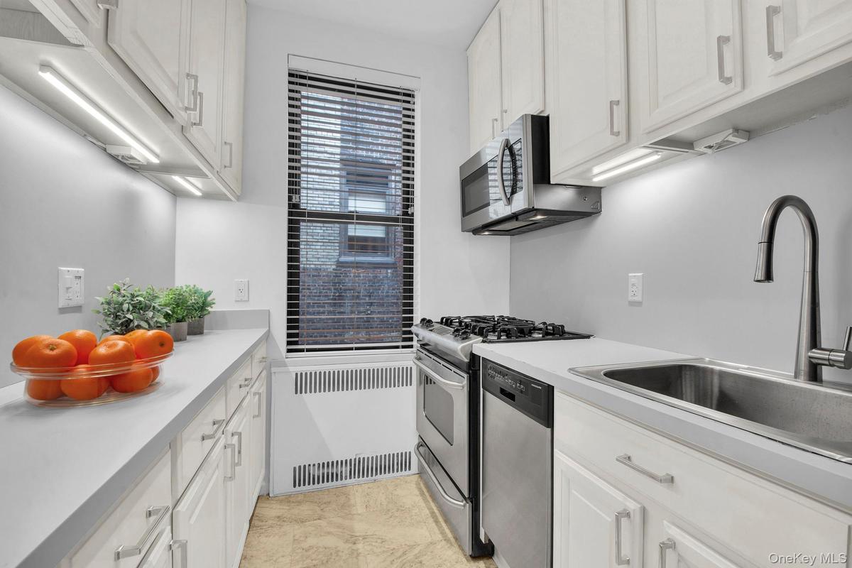 Abundant cabinet space with window and stainless steel appliances