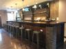 Bar featuring wood walls, decorative light fixtures, and dark hardwood / wood-style floors