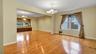 Spare room with a chandelier, light wood-style flooring, a wealth of natural light, and baseboards