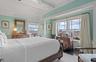 Bedroom with vaulted ceiling with beams, ornamental molding, and wood finished floors