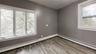 Empty room featuring plenty of natural light, a baseboard heating unit, and light wood-type flooring
