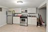 Kitchenette featuring white cabinetry, stainless steel refrigerator, stainless steel range, and tile flooring