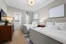 This guest room has crown molding, dual closets, accent lighting and an en-suite bathroom.