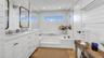 Bathroom with a sink, double vanity, recessed lighting, a bath, and wood finished floors