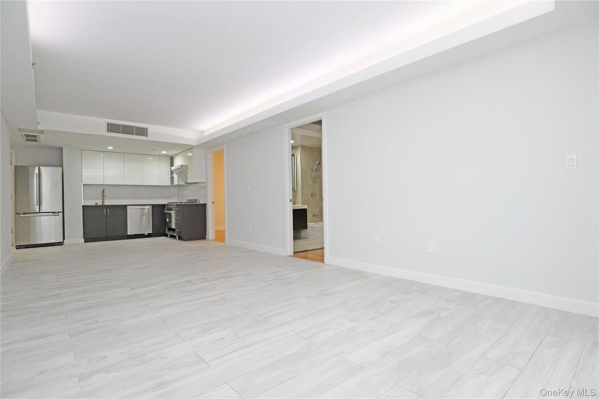 Unfurnished living room featuring a tray ceiling and recessed lighting