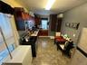 Kitchen with a wall unit AC, stainless steel microwave, electric stove, a sink, and dark brown cabinets
