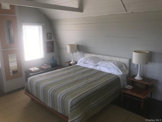 Bedroom with tile patterned floors and lofted ceiling