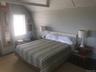 Bedroom with tile patterned floors and lofted ceiling