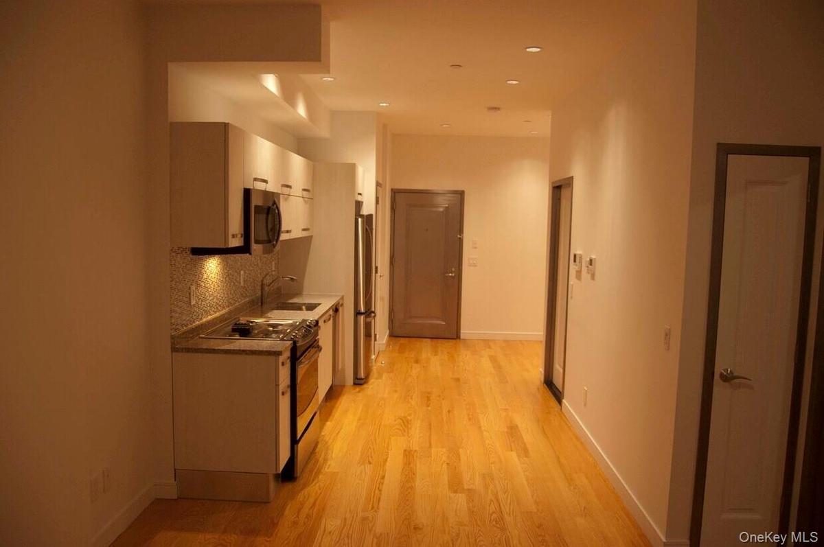 Kitchen with stainless steel appliances, backsplash, light wood finished floors, white cabinets, and recessed lighting