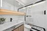 Full bath featuring toilet, a marble finish shower, and vanity