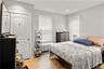 Bedroom featuring wood-finish flooring and two windows with blinds