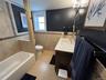 Full bath with vanity, tile walls, a wainscoted wall, shower / washtub combination, and light tile patterned floors