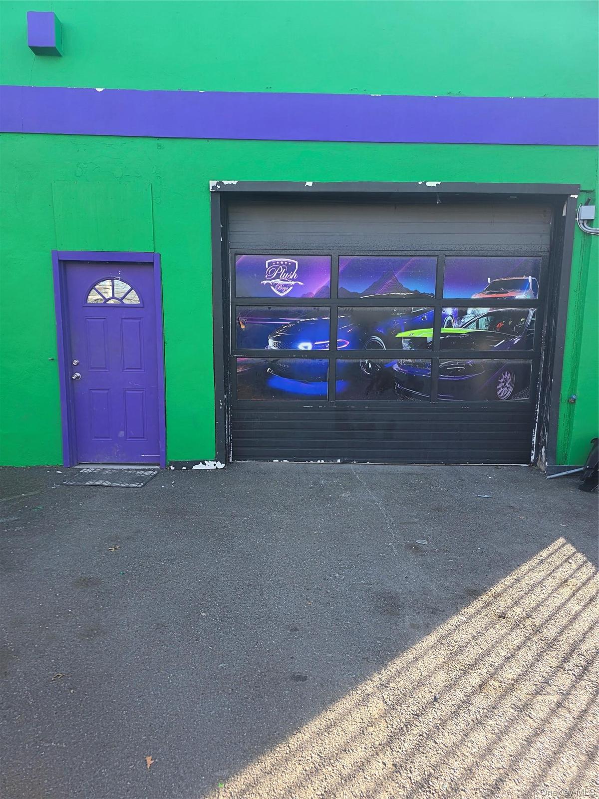 Commercial building exterior featuring a vibrant green facade with a purple accent band