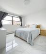 Bedroom with marble look tile flooring and baseboard heating