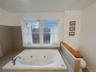 Bathroom featuring toilet and a whirlpool tub