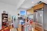 Kitchen featuring a peninsula, recessed lighting, stainless steel appliances, decorative backsplash, and wall chimney exhaust hood