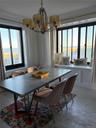 Dining area with a chandelier, crown molding, light wood-style flooring, and a water view