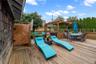 Wooden terrace featuring a hot tub, outdoor dining area, and a fenced backyard