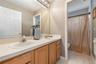 Upstairs full bathroom featuring a separated vanity area and shower, ideal for shared use and added privacy.