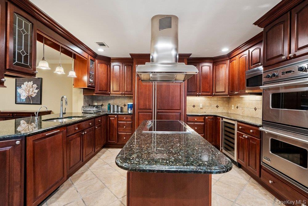 Kitchen featuring extensive wood cabinetry, granite countertops, and stainless steel appliances