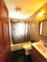 Full bath with shower / bath combination with curtain, vanity, and dark tile patterned floors