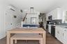 Kitchen featuring stainless steel appliances, a wall unit AC, a sink, and white cabinetry