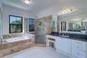 Primary bathroom with updates to garden tub, shower and glass enclosure; separate vanities with granite counter tops and small make up area