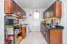 Kitchen featuring white range with gas cooktop, black microwave, light tile patterned floors, and dark stone counters