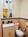 Bathroom with tile walls, vanity, a wainscoted wall, and toilet