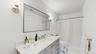 Full bathroom featuring visible vents, toilet, tiled shower, and vanity