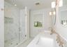 Bathroom featuring light marble finish flooring, a marble finish shower, double vanity, and recessed lighting