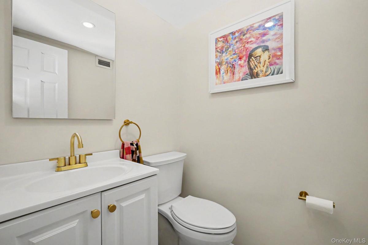 A beautifully renovated powder room adds a sophisticated touch to the main level, featuring stylish finishes, decorative lighting, and an elegant stat