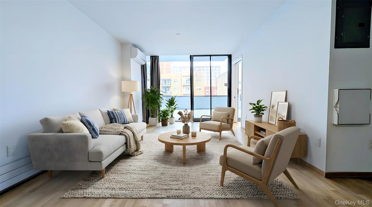 Living area featuring a wall of windows, electric panel, light wood-type flooring, and a wall unit AC