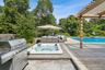 View of patio with an outdoor hot tub, an outdoor living space, a grill, a pergola, and an outdoor pool