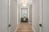 The entry way to the primary suite has double doors, beautiful lighting and a window overlooking the beautifully landscaped yard.