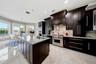 Chef's kitchen with granite counters that continue onto the backsplash