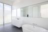 Bathroom with tasteful backsplash, a washtub, and vanity