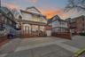 Front exterior elevation of 37-47 76th Street, Jackson Heights, NY 11372, featuring a three-family residence with a private driveway, attached garage,