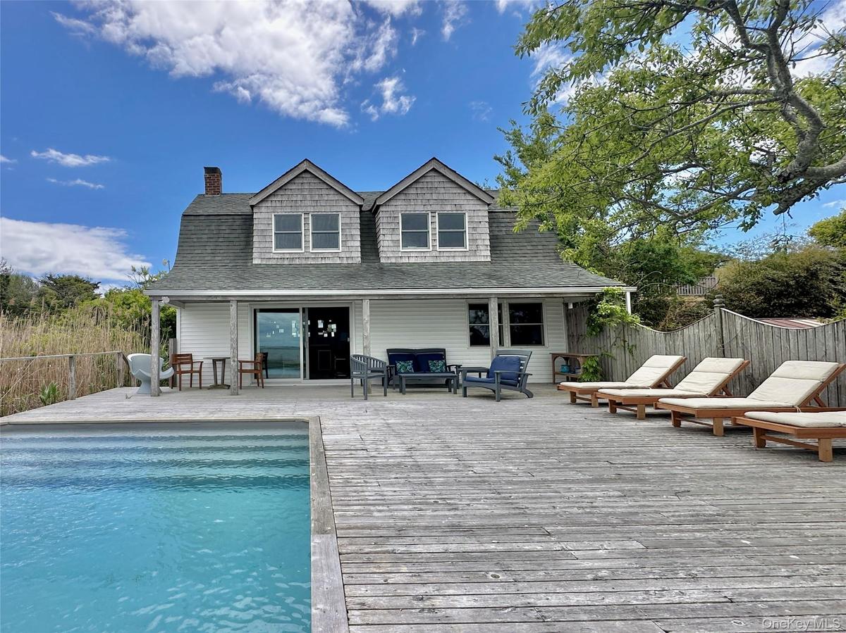 Rear view of property with a deck, a chimney, roof with shingles, and outdoor lounge area