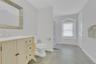 Full bathroom with light tile patterned flooring, vanity, and a shower with curtain