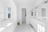 Full bathroom with double vanity, a bath, and ornamental molding
