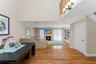 Open-concept living space featuring wood-finish flooring, a fireplace, arched built-in shelving, a sliding glass door, and recessed lighting