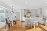 Kitchen with light countertops, a kitchen island,  dishwasher, and light wood floors