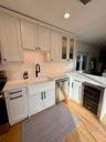 Kitchen with sink, wine cooler, light hardwood / wood-style floors, white cabinetry, and stainless steel appliances