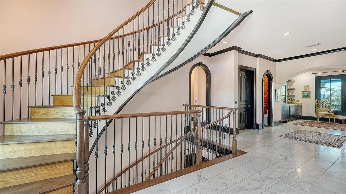 Grand curved staircase with custom ironwork