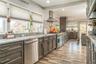 Kitchen with wall chimney exhaust hood, sink, stainless steel appliances, and plenty of natural light