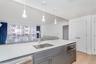 Kitchen with light stone countertops, gray cabinetry, appliances with stainless steel finishes, light wood-type flooring, and recessed lighting