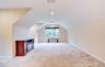 Spacious bonus room featuring sloped ceilings, recessed lighting, a window with exterior visibility, and light-toned carpeting