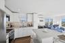 Kitchen with a breakfast bar, white cabinets, stainless steel appliances, modern cabinets, and recessed lighting